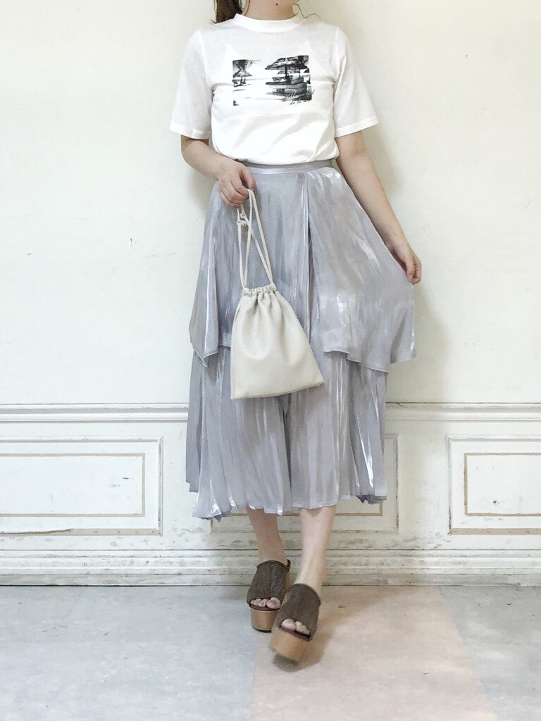 グレー系のスカート、ホワイト系のハンドバッグ、ホワイト系のTシャツ/カットソーを着用したレディースの夏コーディネートの2枚目の写真