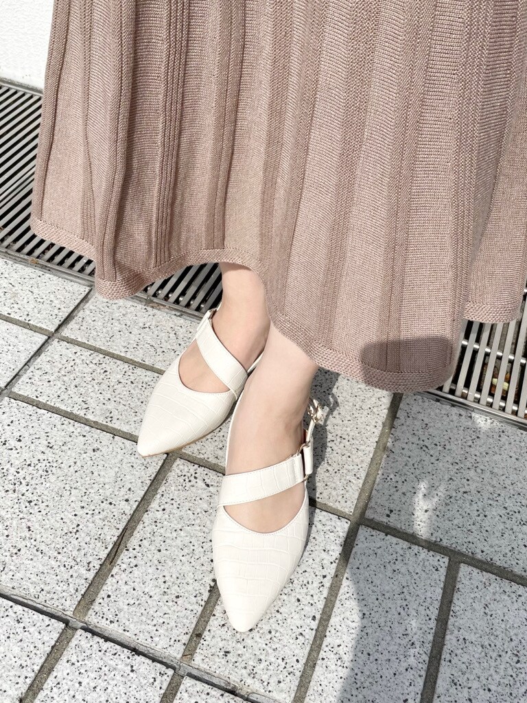 ベージュ系のワンピース、ホワイト系のパンプス、ブラウン系のショルダーバッグを着用したレディースの冬コーディネートの6枚目の写真