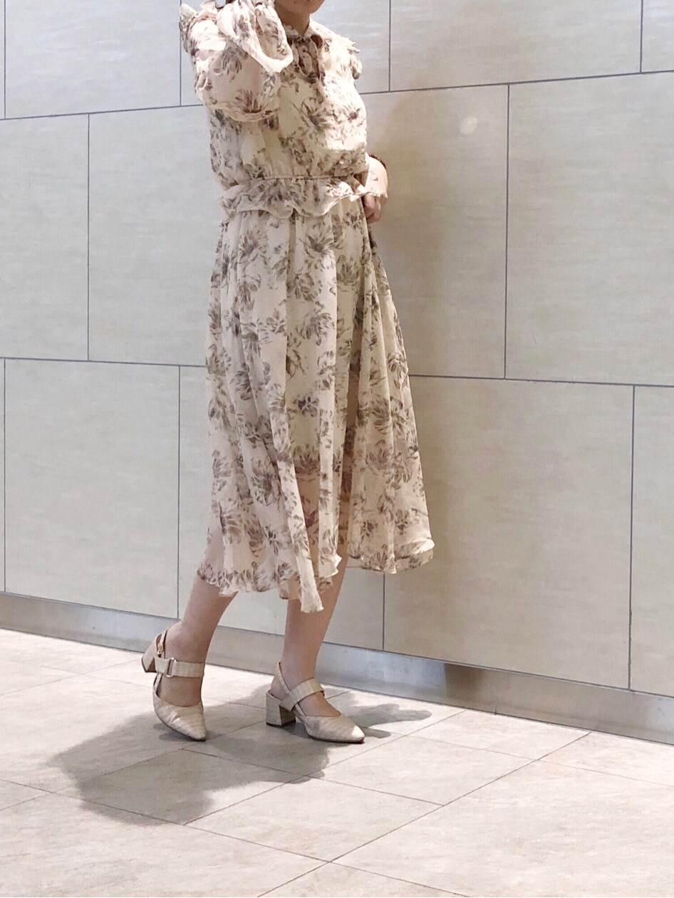 ベージュ系のトレンチコート、ベージュ系のワンピース、ホワイト系のパンプスを着用したレディースの春コーディネートの2枚目の写真