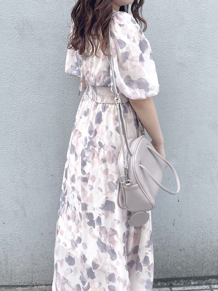 ピンク系のワンピース、ホワイト系のパンプス、ベージュ系のハンドバッグを着用したレディースの春コーディネートの6枚目の写真