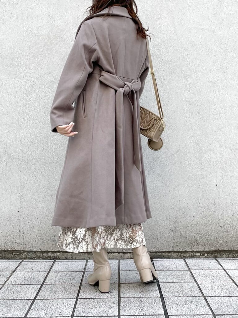 ベージュ系のスカート、ベージュ系のその他アウター、ベージュ系のハンドバッグを着用したレディースの秋コーディネートの2枚目の写真