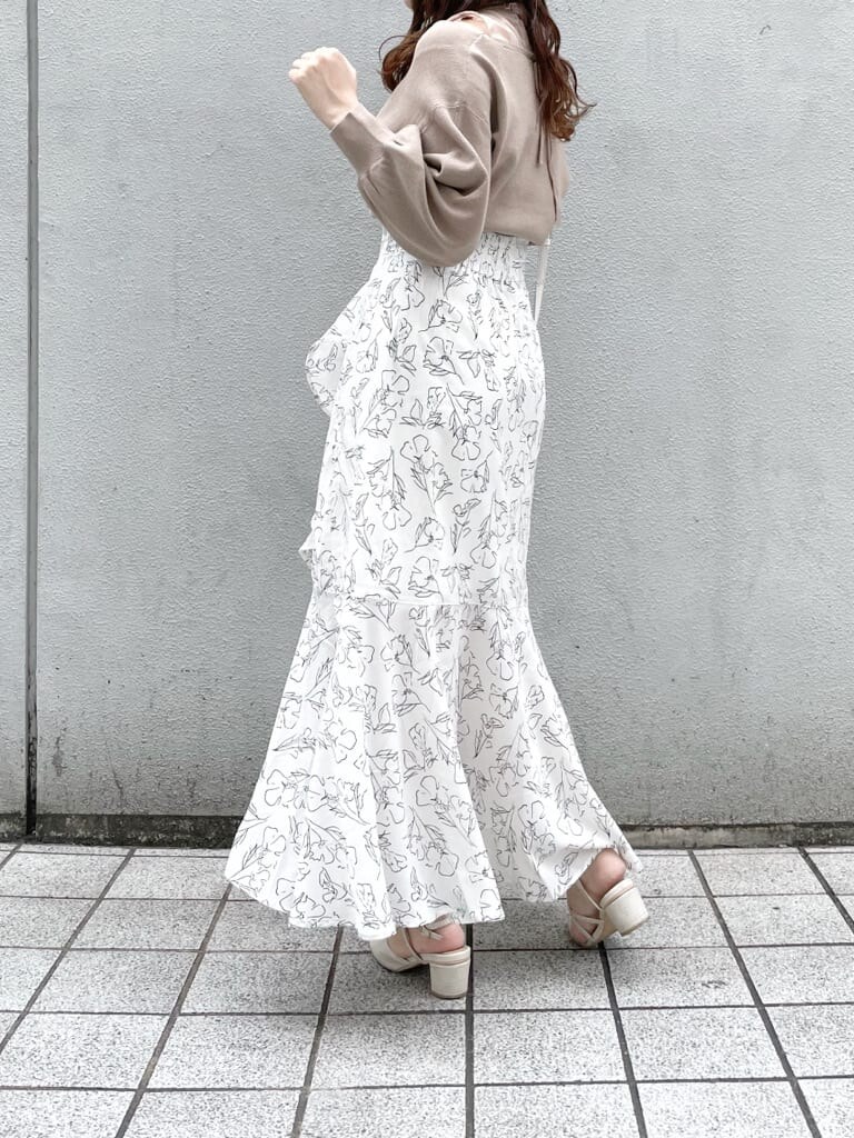 ホワイト系のパンプス、ホワイト系のショルダーバッグ、ホワイト系のスカートを着用したレディースの春コーディネートの2枚目の写真