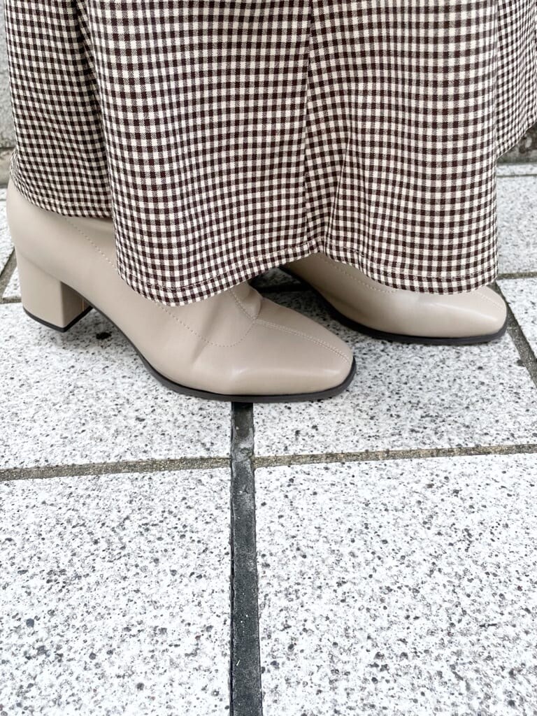 ブラウン系のスカート、ベージュ系のブーツ、ピンク系のニット/セーターを着用したレディースの秋コーディネートの7枚目の写真