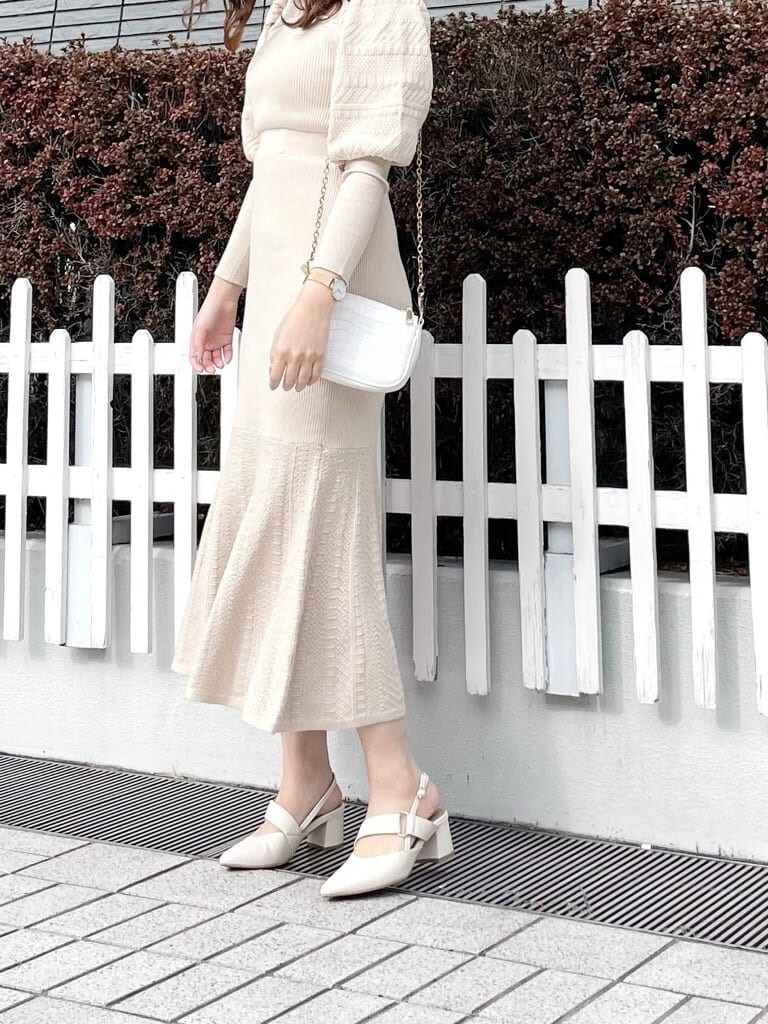 グレー系のトレンチコート、ホワイト系のワンピース、ホワイト系のパンプスを着用したレディースの春コーディネートの6枚目の写真