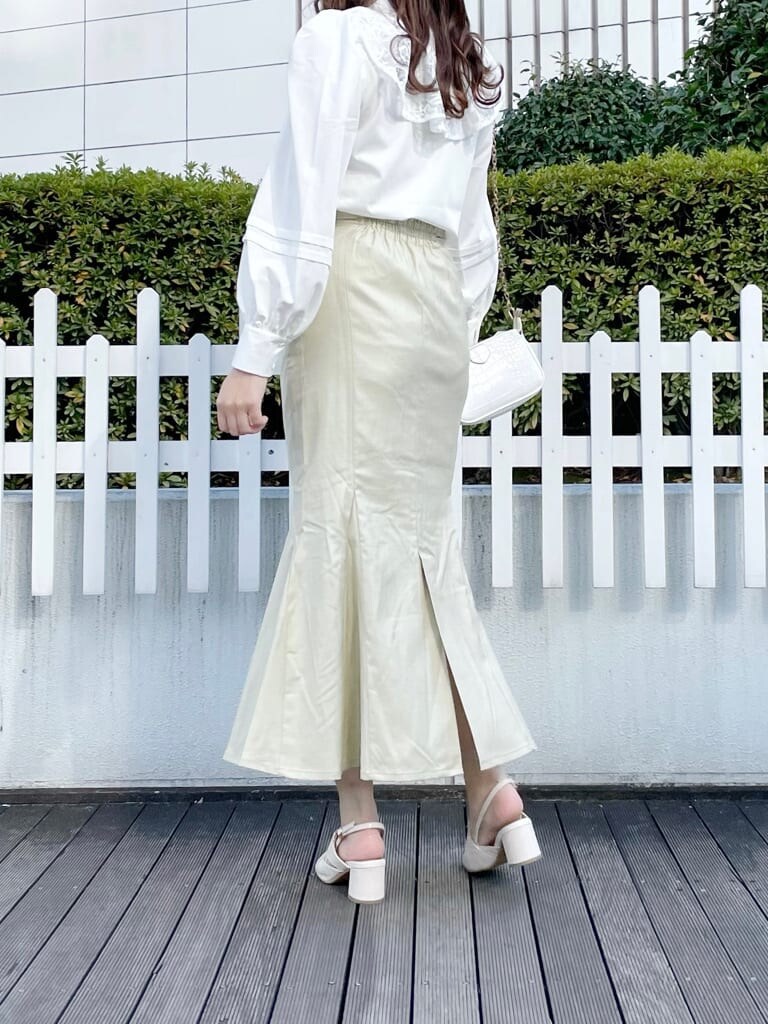 ホワイト系のシャツ/ブラウス、グリーン系のスカート、ホワイト系のパンプスを着用したレディースの春コーディネートの2枚目の写真