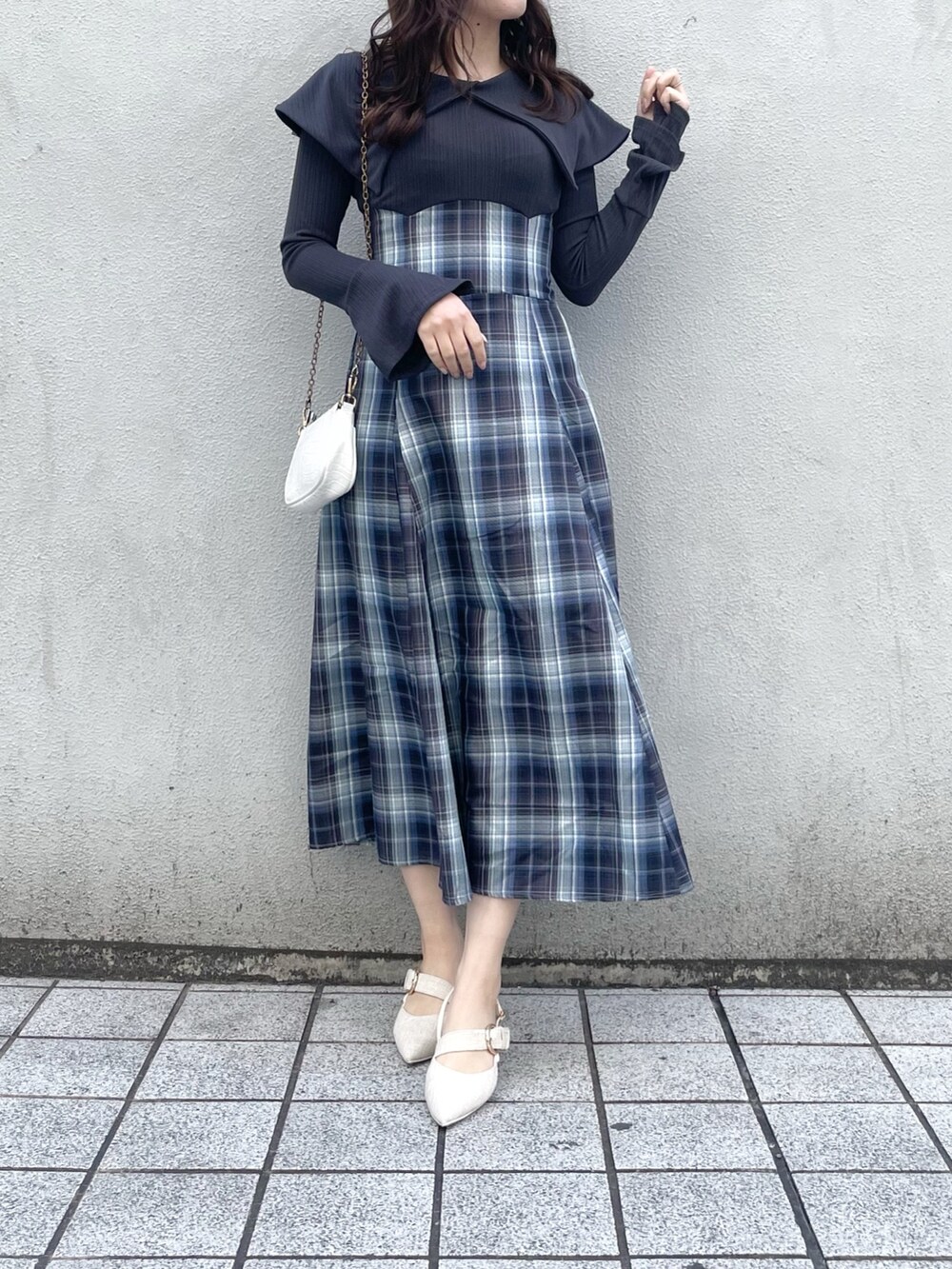 ブルー系のワンピース、ホワイト系のパンプスを着用したレディースの冬コーディネートの2枚目の写真