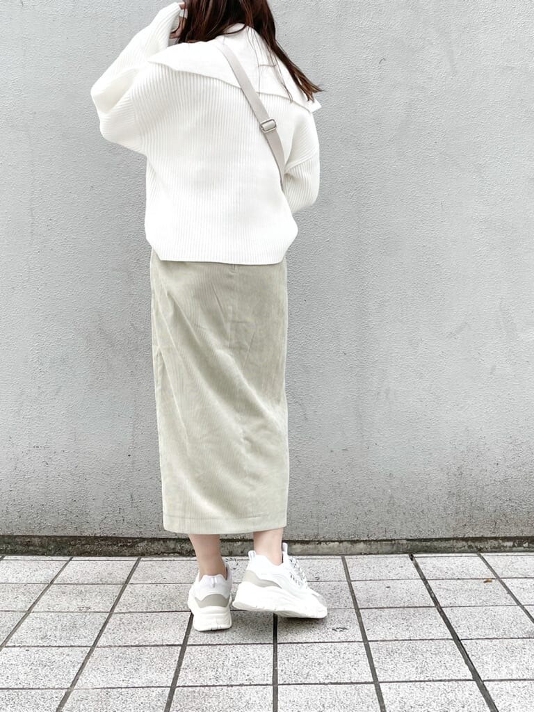 ホワイト系のスニーカー、グリーン系のスカート、ホワイト系のハンドバッグを着用したレディースの秋コーディネートの3枚目の写真