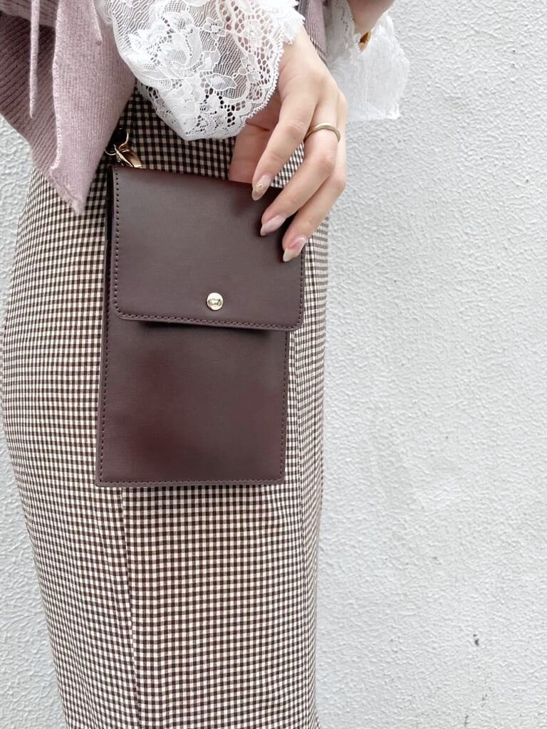 ブラウン系のスカート、ベージュ系のブーツ、ピンク系のニット/セーターを着用したレディースの秋コーディネートの6枚目の写真