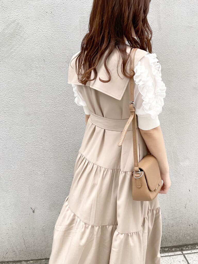 ベージュ系のワンピース、ホワイト系のパンプス、ブラウン系のショルダーバッグを着用したレディースの春コーディネートの7枚目の写真