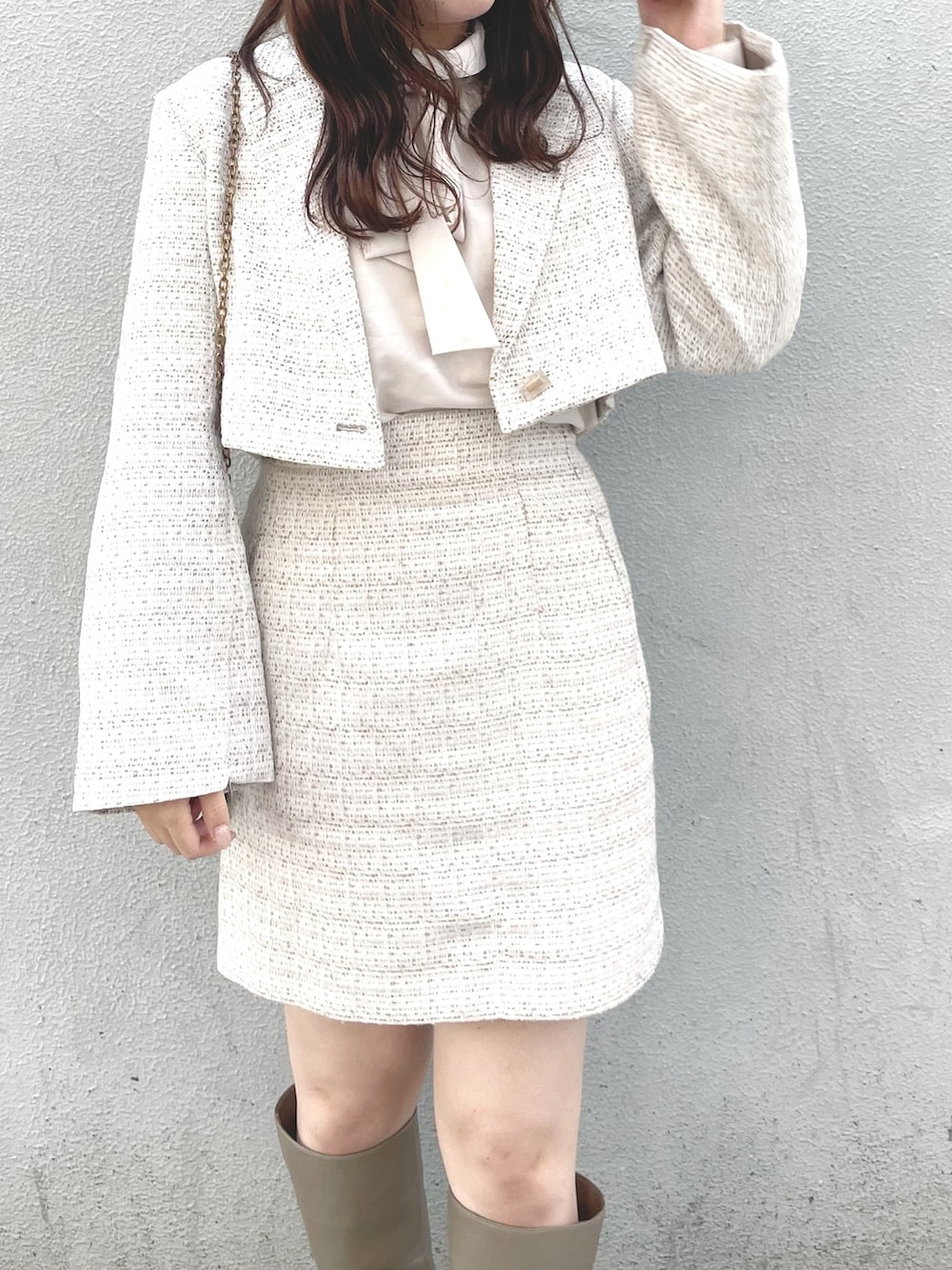 ホワイト系のその他アウター、ホワイト系のスカート、ベージュ系のブーツを着用したレディースの冬コーディネートの3枚目の写真