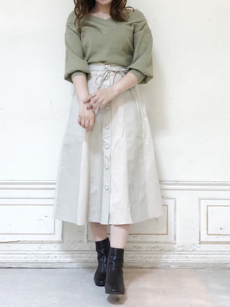 ホワイト系のスカート、ブラウン系のブーツ、グリーン系のニット/セーターを着用したレディースの秋コーディネートの2枚目の写真