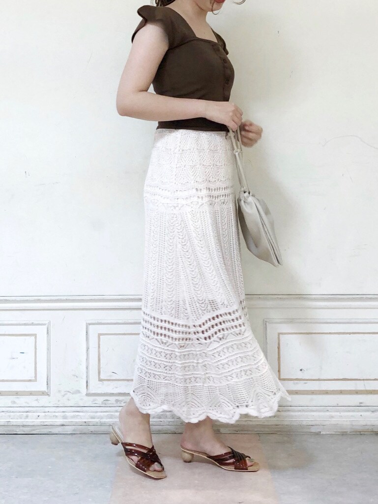 ホワイト系のスカート、ホワイト系のハンドバッグ、ブラウン系のサンダルを着用したレディースの夏コーディネートの3枚目の写真