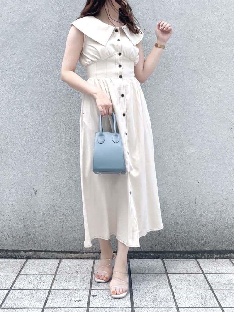 パープル系のサンダル、ブルー系のハンドバッグ、ホワイト系のワンピースを着用したレディースの夏コーディネートの3枚目の写真