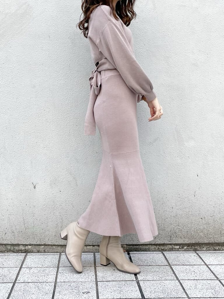 ホワイト系のブルゾン、ベージュ系のブーツ、ベージュ系のハンドバッグを着用したレディースの秋コーディネートの6枚目の写真