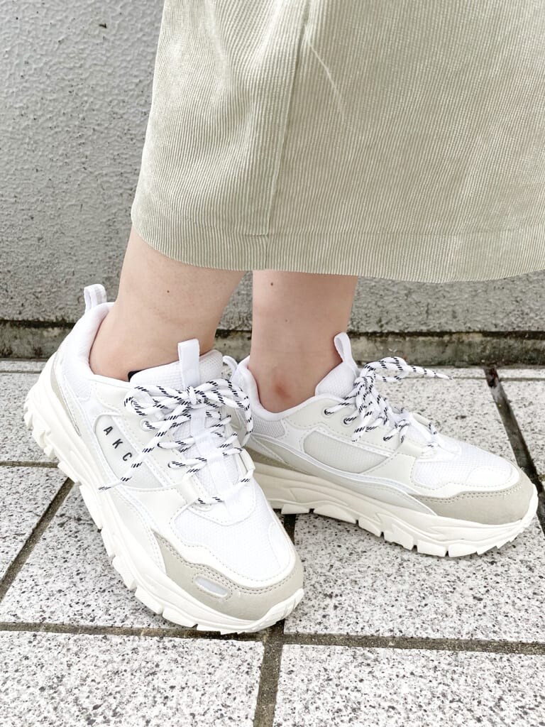 ホワイト系のスニーカー、グリーン系のスカート、ホワイト系のハンドバッグを着用したレディースの秋コーディネートの9枚目の写真