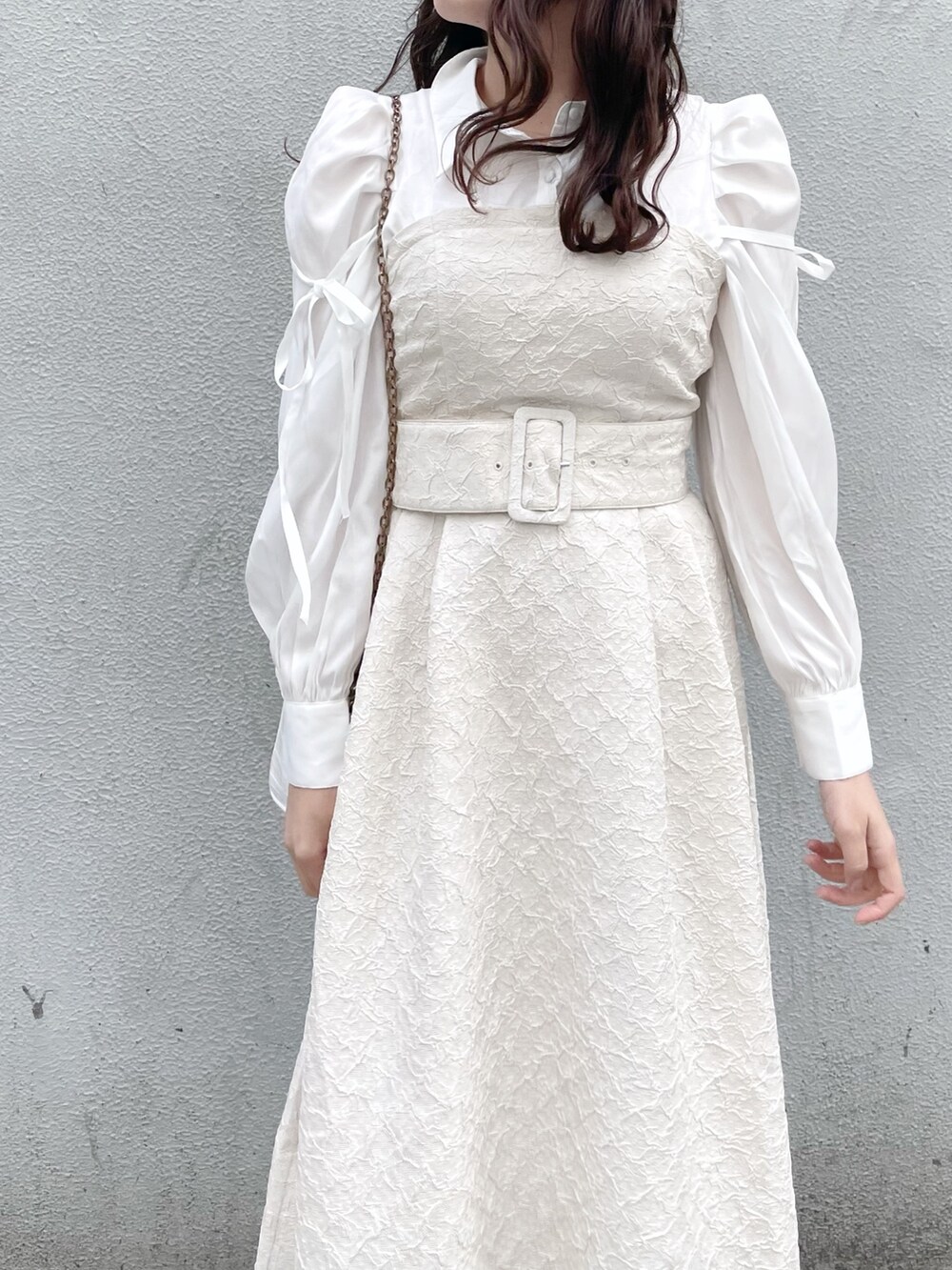 ホワイト系のワンピース、ホワイト系のパンプスを着用したレディースの冬コーディネートの5枚目の写真