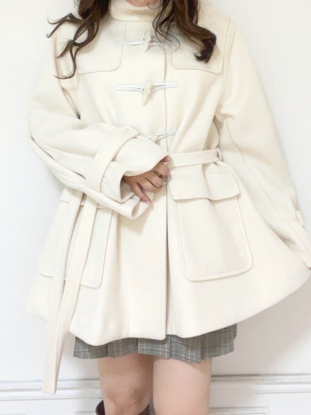 ホワイト系のダッフルコート、ピンク系のニット/セーター、その他のスカートを着用したレディースの秋コーディネートの2枚目の写真