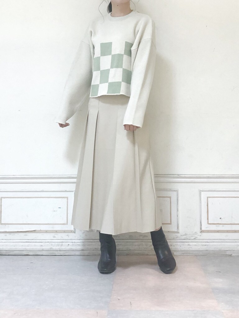 ベージュ系のスカート、グリーン系のニット/セーター、グリーン系のチェスターコートを着用したレディースの秋コーディネートの4枚目の写真