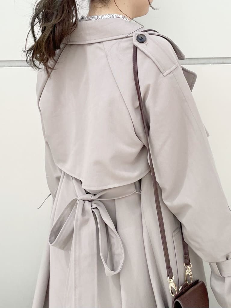 ブラウン系のワンピース、グレー系のトレンチコート、ベージュ系のブーツを着用したレディースの秋コーディネートの4枚目の写真