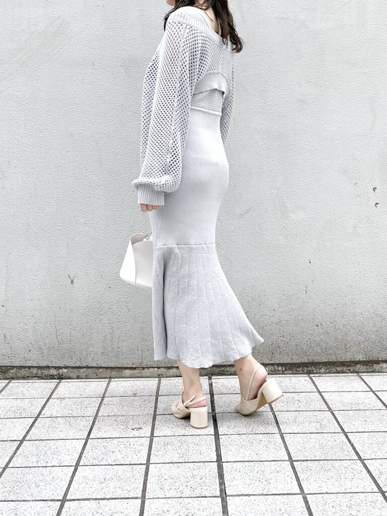 グレー系のワンピース、ホワイト系のハンドバッグ、ホワイト系のパンプスを着用したレディースの秋コーディネートの2枚目の写真