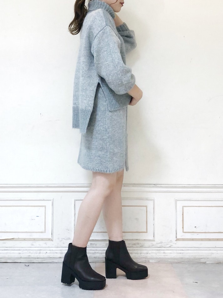 グレー系のスカート、グレー系のニット/セーター、ブラウン系のブーツを着用したレディースの秋コーディネートの3枚目の写真