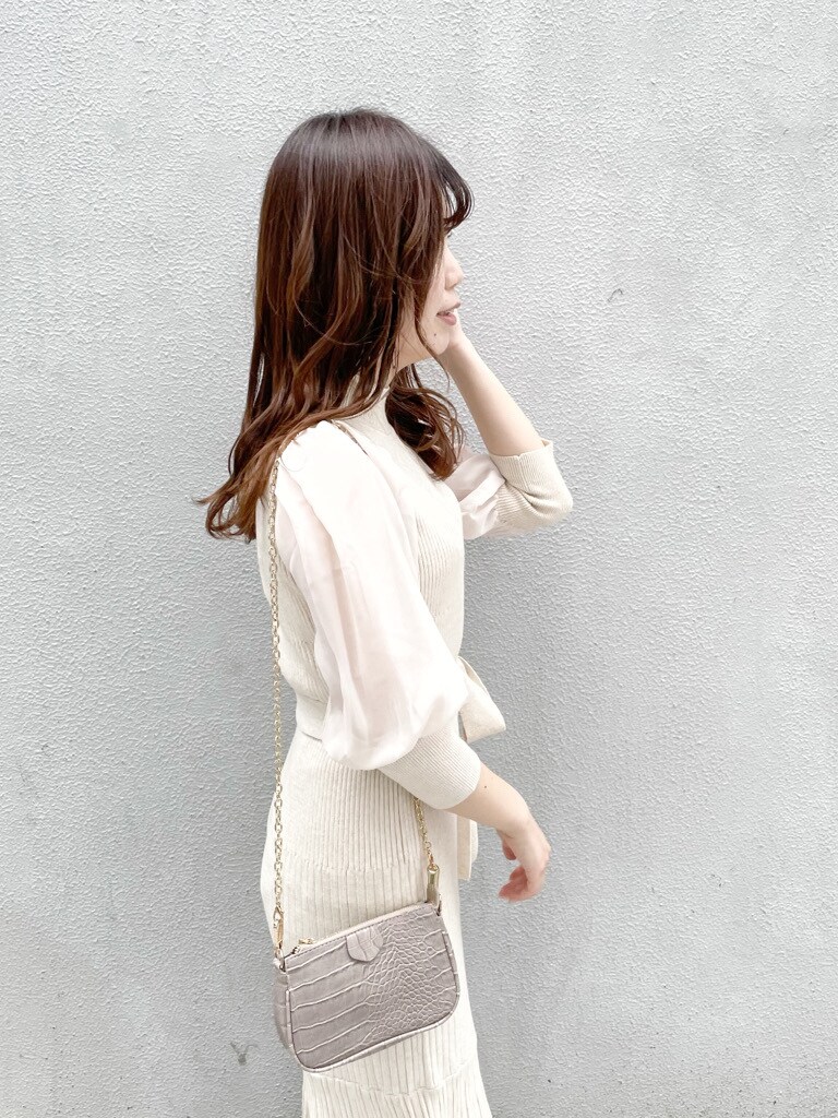 ベージュ系のワンピース、ホワイト系のパンプス、ベージュ系のショルダーバッグを着用したレディースの冬コーディネートの4枚目の写真