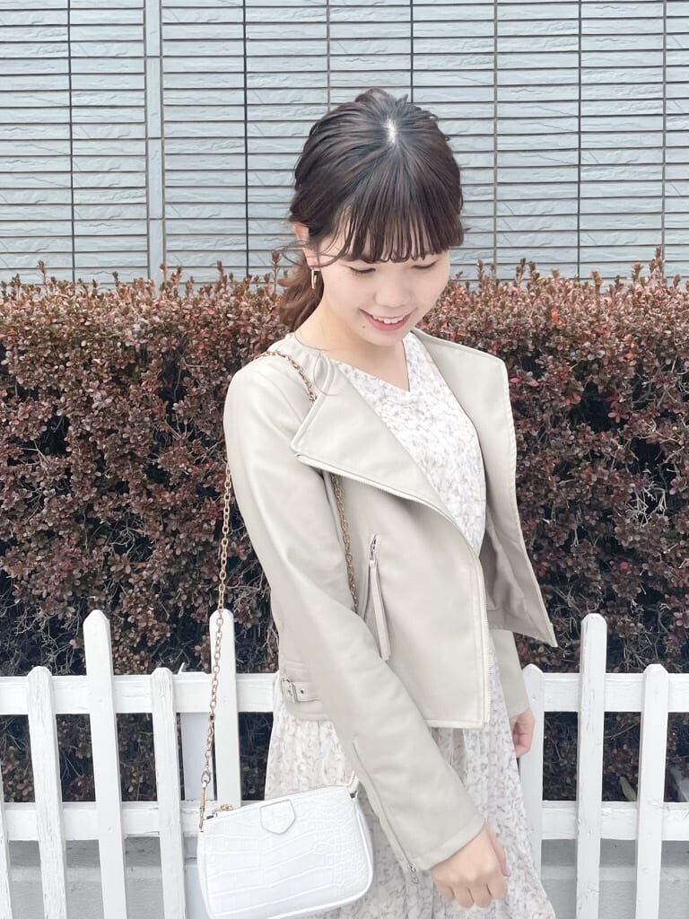 ベージュ系のテーラードジャケット、ホワイト系のパンプス、オレンジ系のワンピースを着用したレディースの冬コーディネートの3枚目の写真