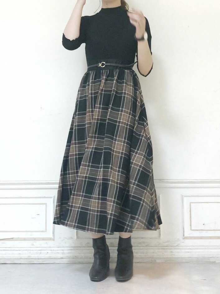 ブラウン系のブーツ、グリーン系のチェスターコート、ブラック系のワンピースを着用したレディースの秋コーディネートの7枚目の写真