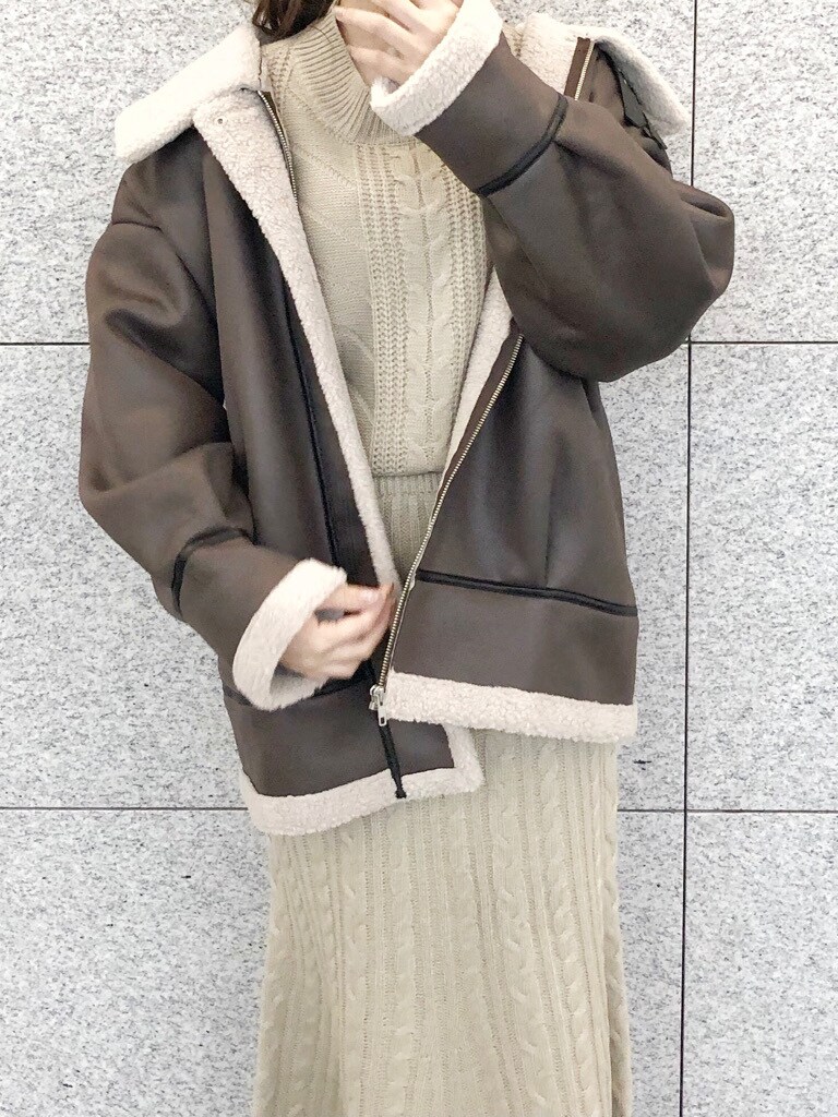 ブラウン系のブーツ、ブラウン系のブルゾン、ベージュ系のワンピースを着用したレディースの冬コーディネートの4枚目の写真