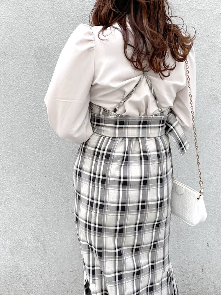 グレー系のジャンパースカート、ホワイト系のパンプス、ベージュ系のシャツ/ブラウスを着用したレディースの冬コーディネートの4枚目の写真