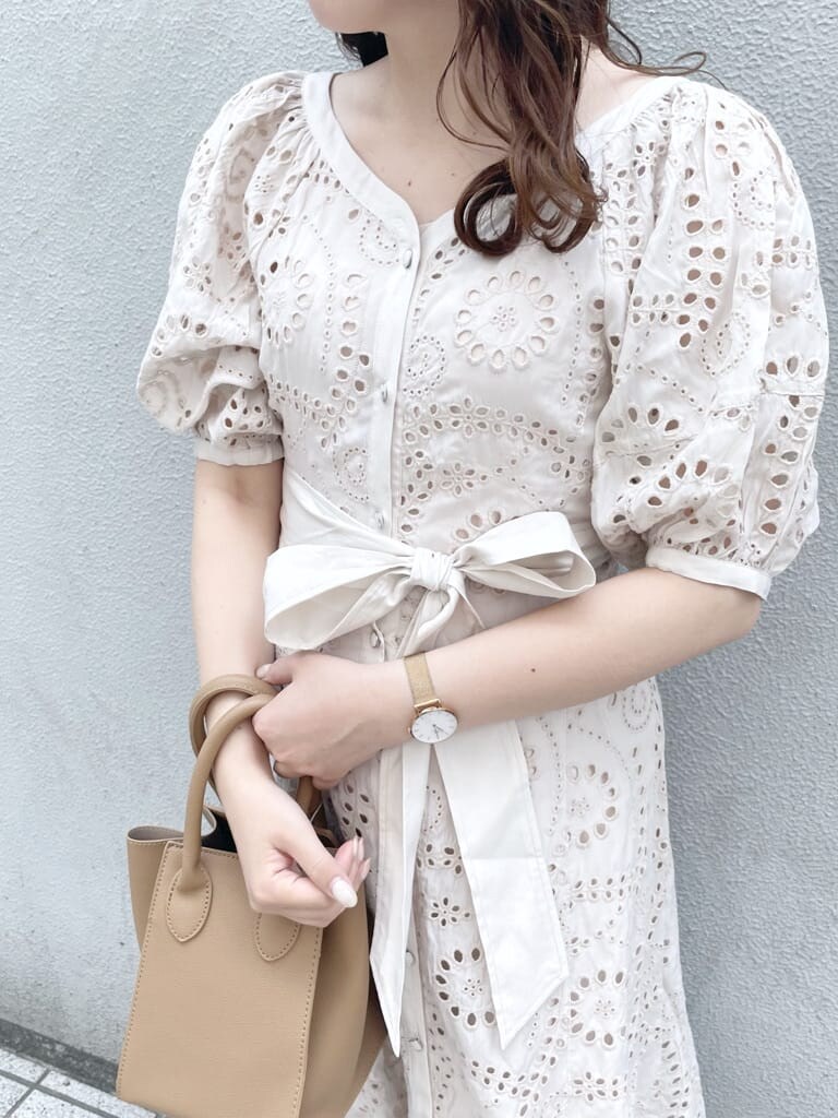ホワイト系のワンピース、ベージュ系のハンドバッグ、ホワイト系のパンプスを着用したレディースの春コーディネートの7枚目の写真
