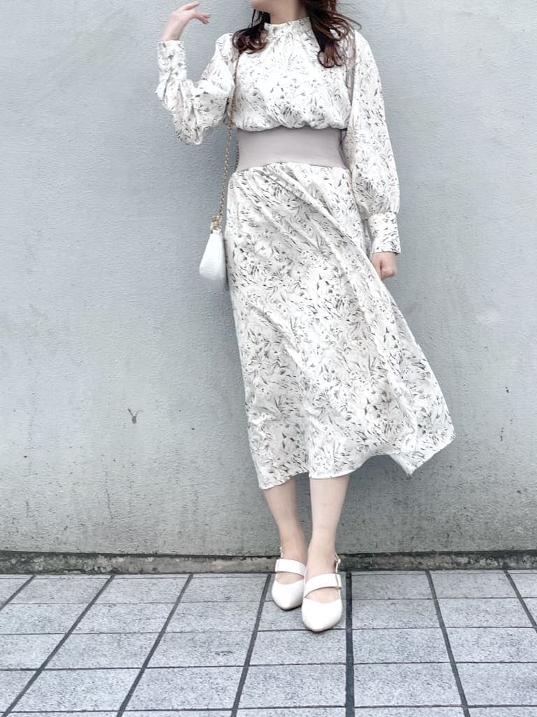 グレー系のトレンチコート、ホワイト系のワンピース、ホワイト系のパンプスを着用したレディースの冬コーディネートの6枚目の写真