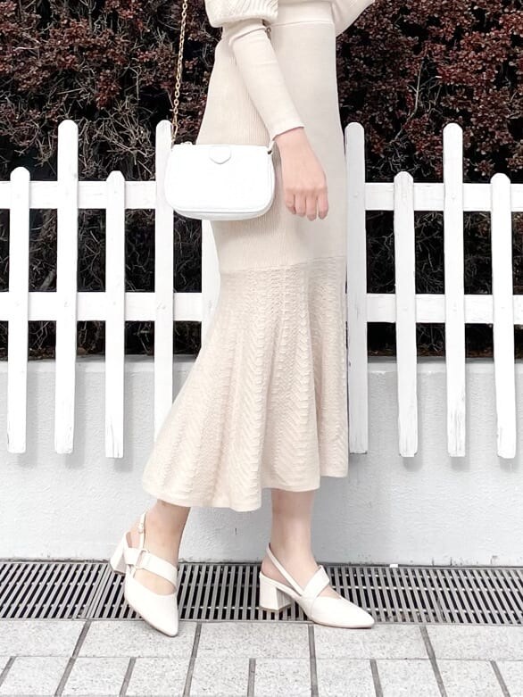 グレー系のトレンチコート、ホワイト系のワンピース、ホワイト系のパンプスを着用したレディースの春コーディネートの7枚目の写真