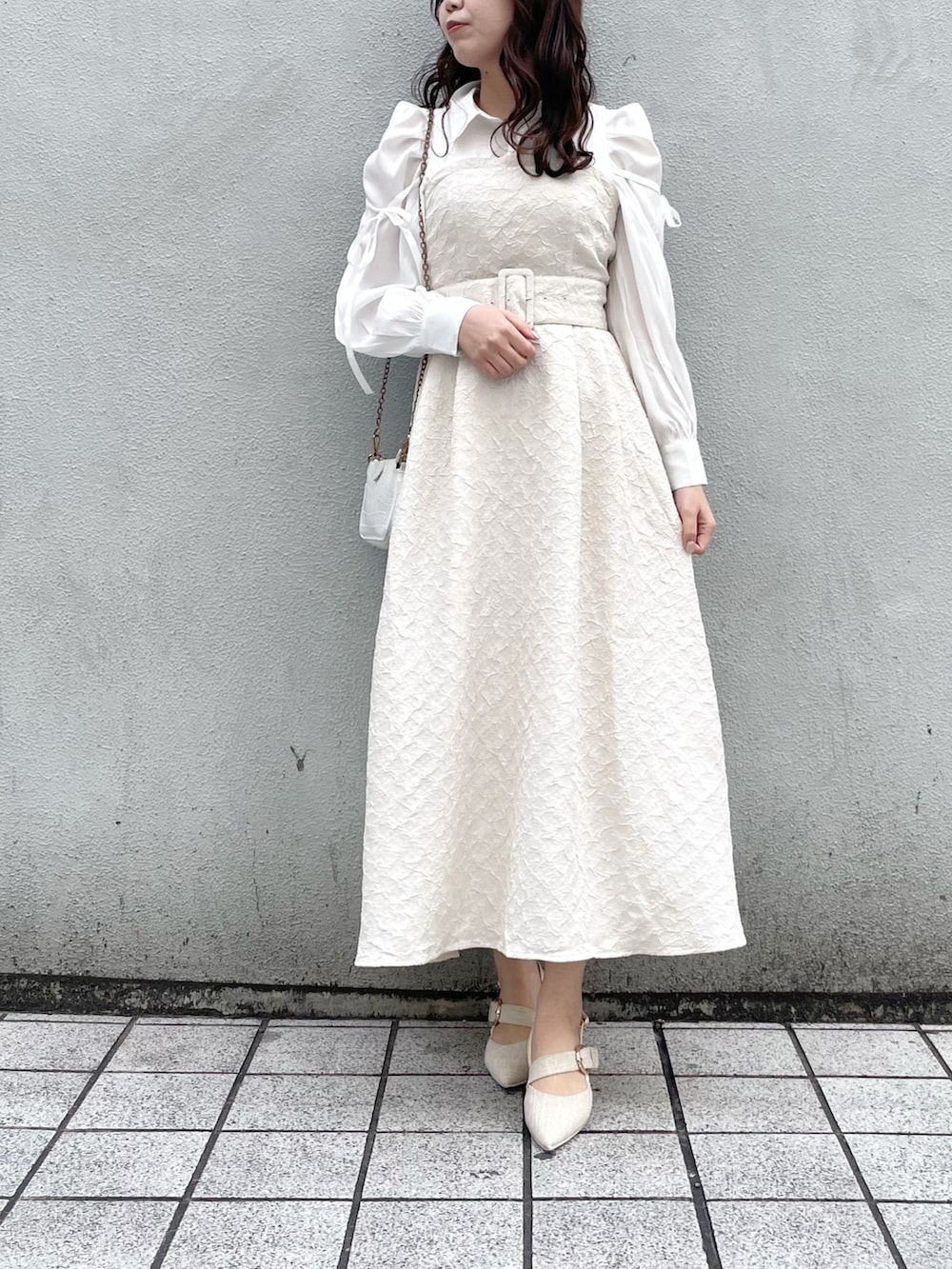 ホワイト系のワンピース、ホワイト系のパンプスを着用したレディースの冬コーディネートの2枚目の写真