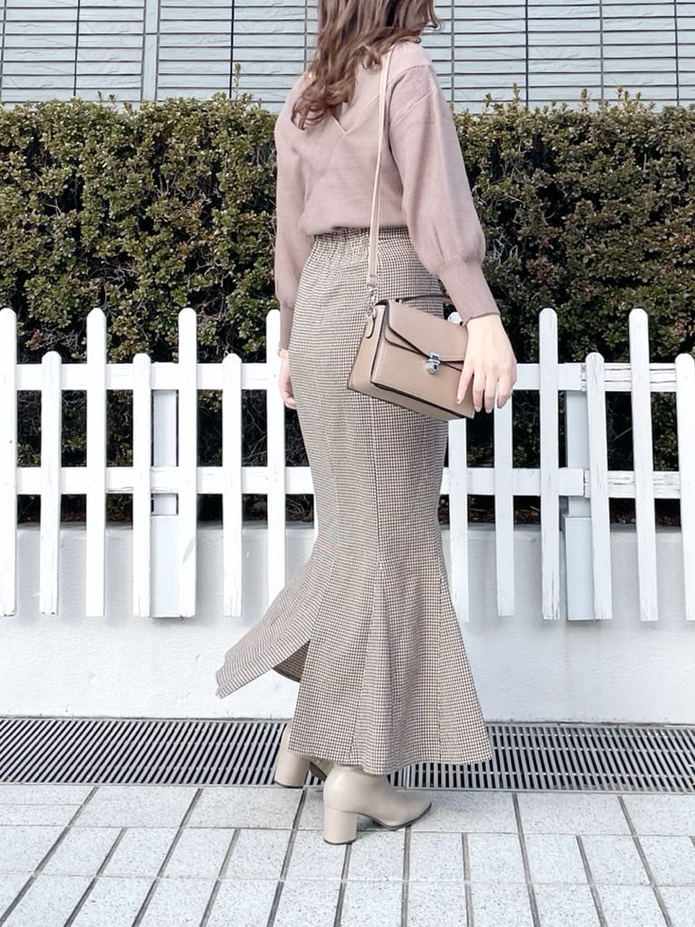 ベージュ系のブーツ、ブラウン系のニット/セーター、ブラウン系のスカートを着用したレディースの冬コーディネートの2枚目の写真