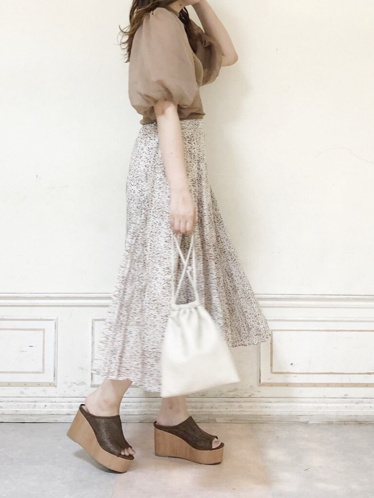 ホワイト系のハンドバッグ、ホワイト系のスカート、ブラウン系のサンダルを着用したレディースの夏コーディネートの2枚目の写真