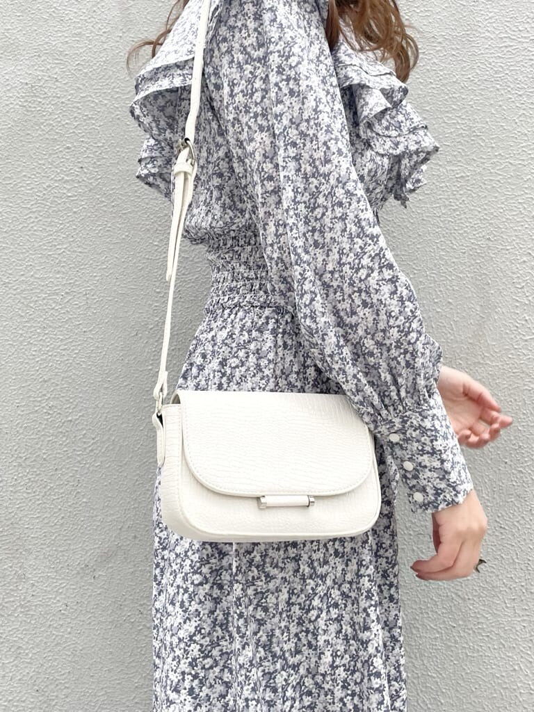 ブルー系のワンピース、ホワイト系のローファー、ホワイト系のショルダーバッグを着用したレディースの冬コーディネートの7枚目の写真