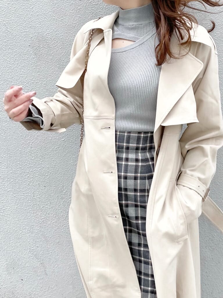 ベージュ系のトレンチコート、ブラック系のスカート、グリーン系のニット/セーターを着用したレディースの冬コーディネートの4枚目の写真