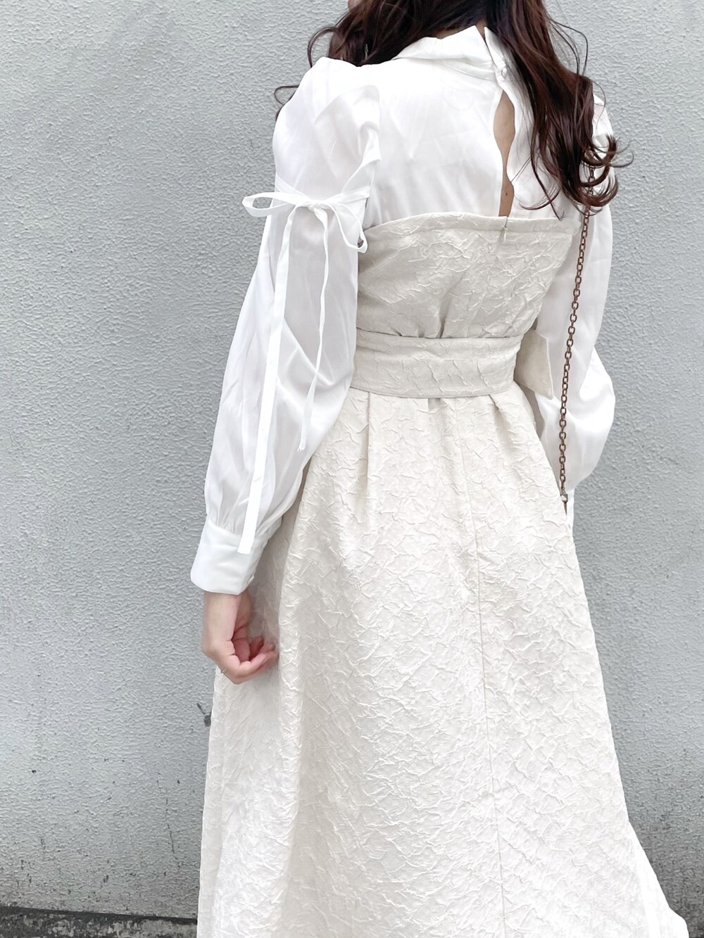 ホワイト系のワンピース、ホワイト系のパンプスを着用したレディースの冬コーディネートの7枚目の写真