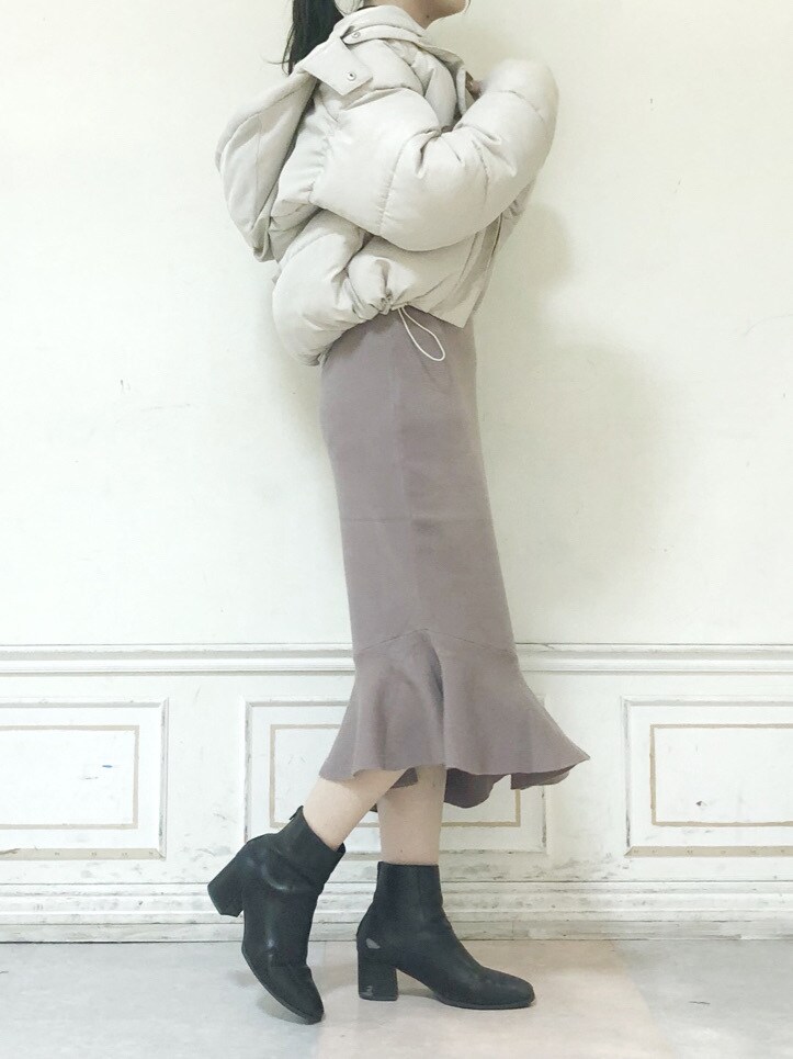 ブラウン系のブーツ、ブラウン系のニット/セーター、ホワイト系のブルゾンを着用したレディースの秋コーディネートの2枚目の写真