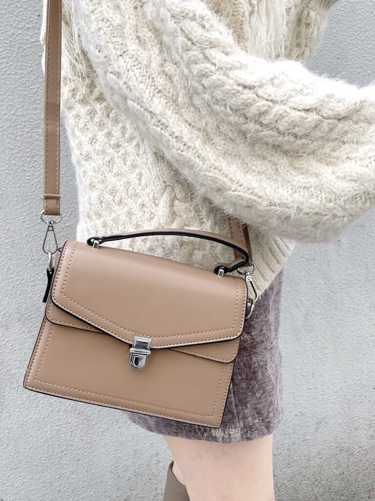 グレー系のスカート、ベージュ系のブーツ、ベージュ系のハンドバッグを着用したレディースの秋コーディネートの7枚目の写真