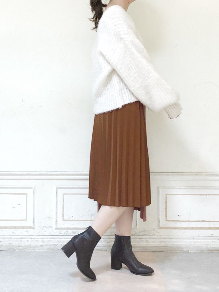 ブラウン系のスカート、ブラウン系のブーツ、ホワイト系のニット/セーターを着用したレディースの秋コーディネートの3枚目の写真