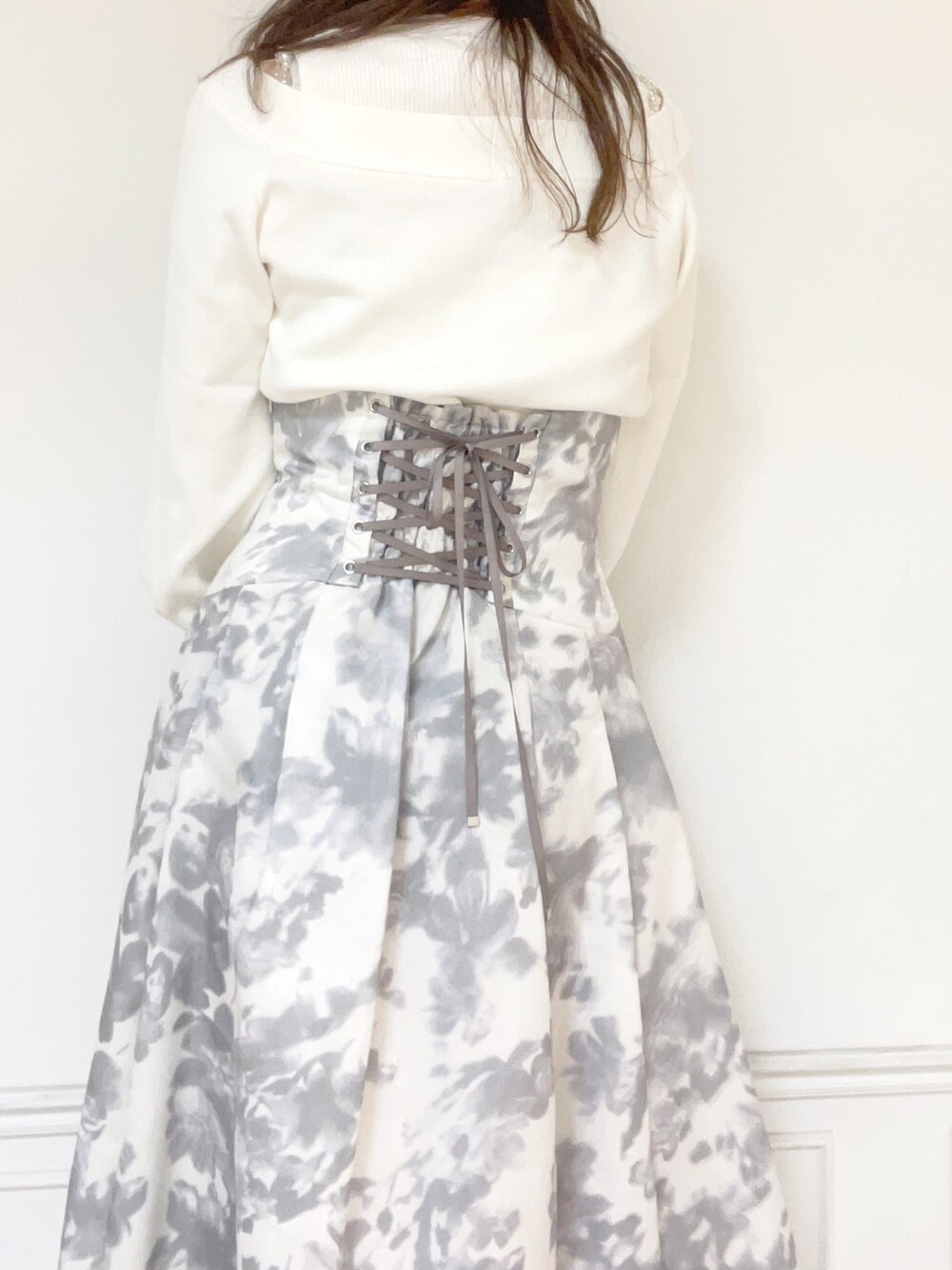 ホワイト系のニット/セーター、ホワイト系のスカート、ホワイト系のブーツを着用したレディースの秋コーディネートの4枚目の写真