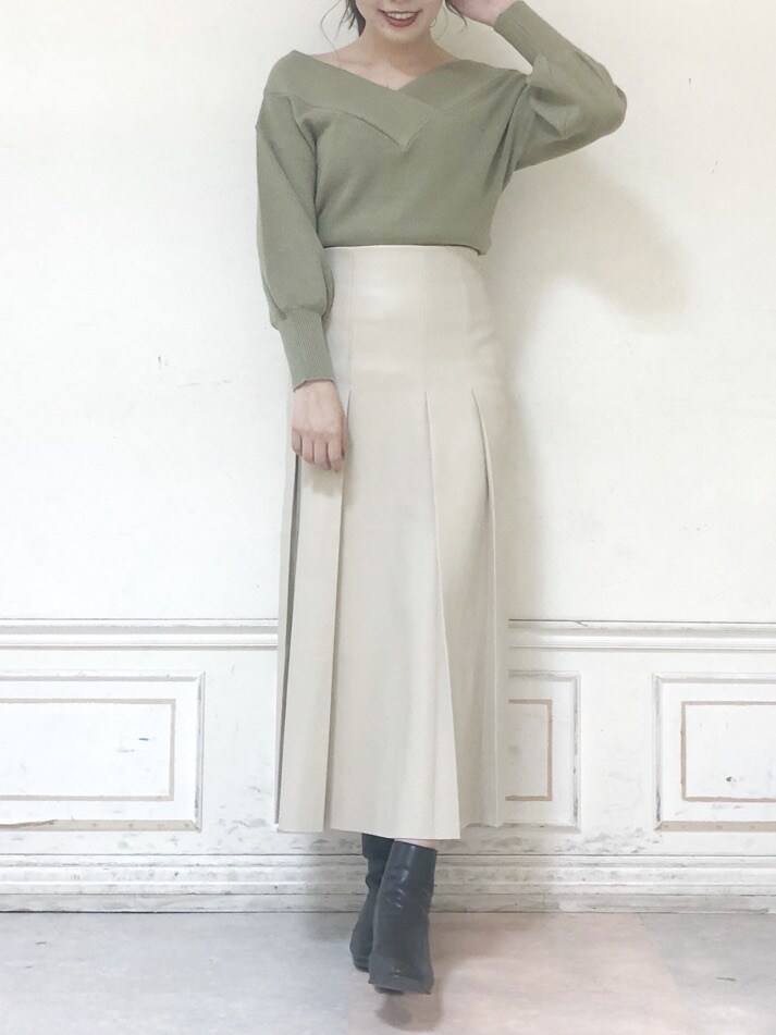 グリーン系のニット/セーター、ベージュ系のスカート、ブラウン系のブーツを着用したレディースの秋コーディネートの4枚目の写真