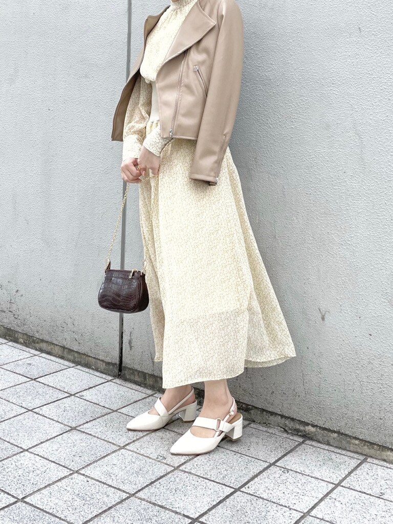 ホワイト系のパンプス、ベージュ系のライダースジャケット、ブラウン系のショルダーバッグを着用したレディースの冬コーディネートの4枚目の写真