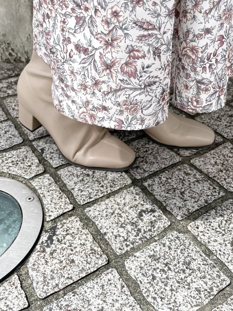 ブラウン系のワンピース、グレー系のトレンチコート、ベージュ系のブーツを着用したレディースの秋コーディネートの8枚目の写真