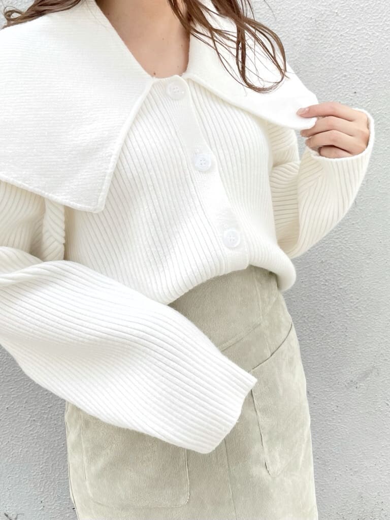 ホワイト系のスニーカー、グリーン系のスカート、ホワイト系のハンドバッグを着用したレディースの秋コーディネートの5枚目の写真