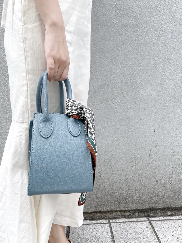 ホワイト系のワンピース、ブルー系のハンドバッグ、ホワイト系のパンプスを着用したレディースの春コーディネートの7枚目の写真