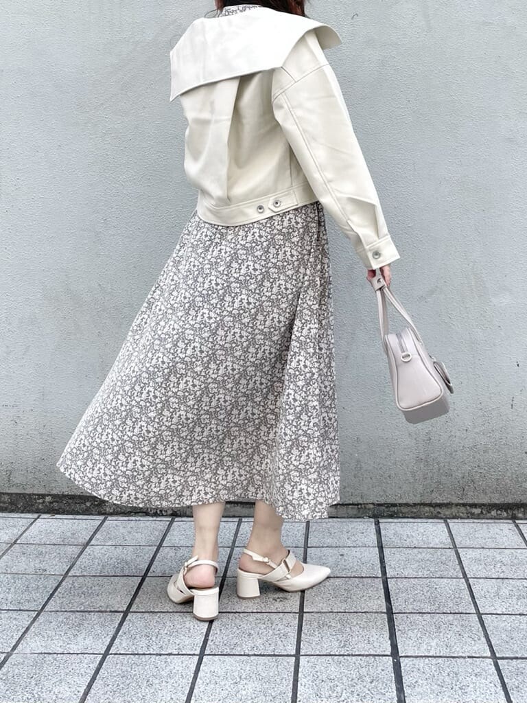 ホワイト系のワンピース、ホワイト系のライダースジャケット、ホワイト系のパンプスを着用したレディースの冬コーディネートの3枚目の写真