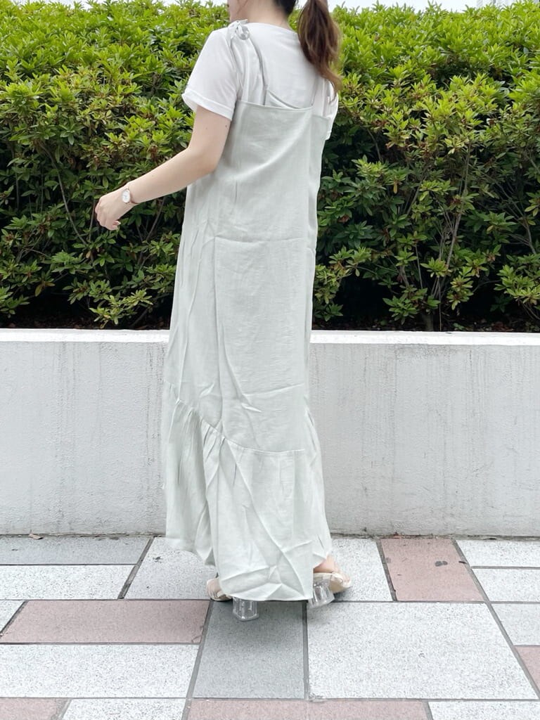 グリーン系のワンピース、ホワイト系のTシャツ/カットソー、ホワイト系のショルダーバッグを着用したレディースの夏コーディネートの2枚目の写真